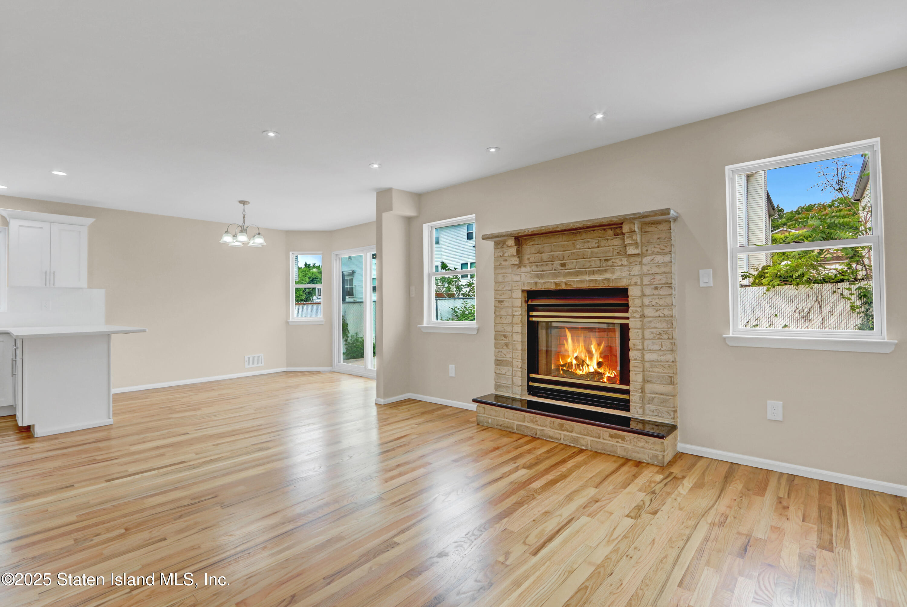 103 Savo Loop Staten Island, NY 10309 - Photo 16 of 46 an empty room with wooden floor fireplace and windows