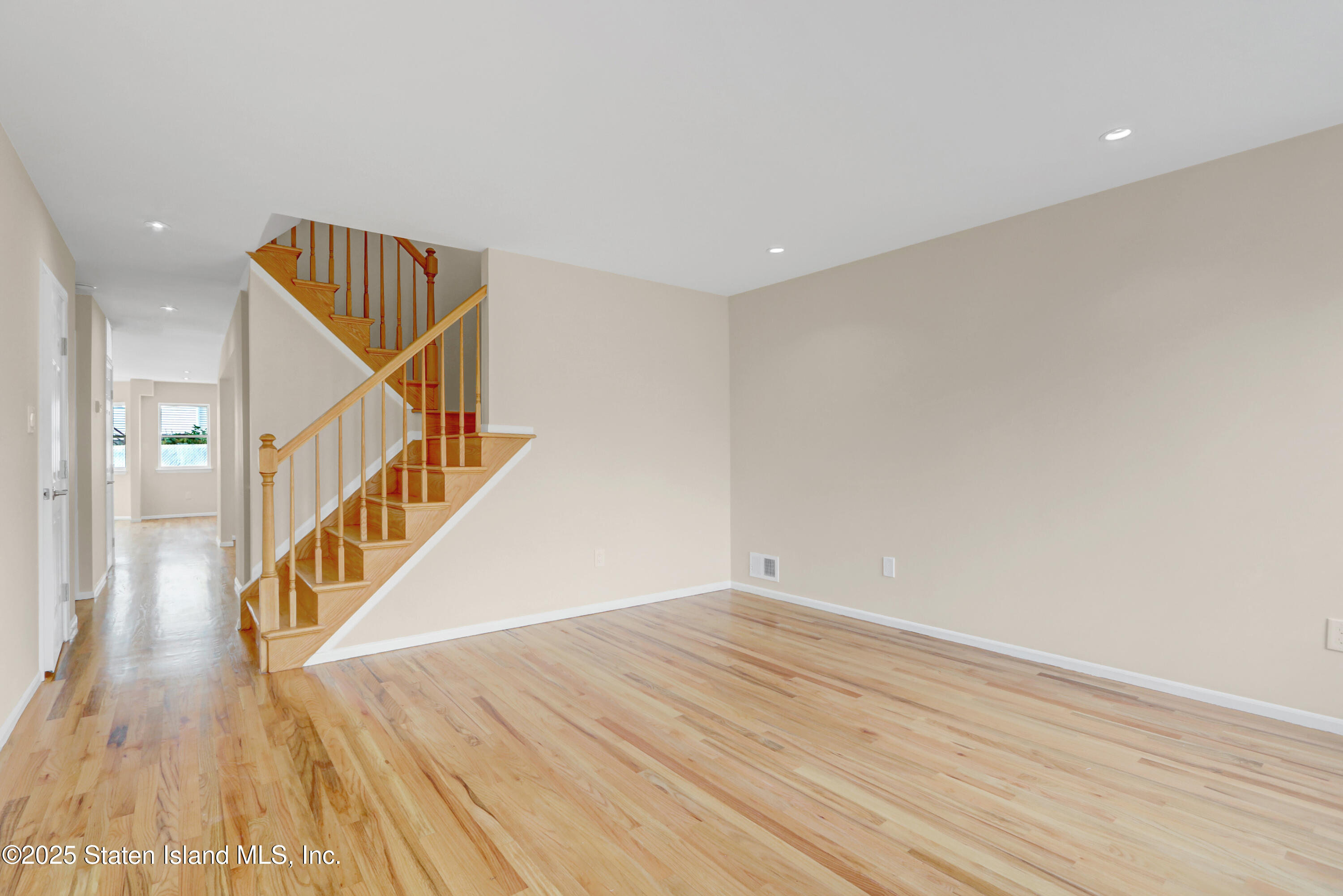 103 Savo Loop Staten Island, NY 10309 - Photo 3 of 46 a view of a hallway with wooden floor and staircase