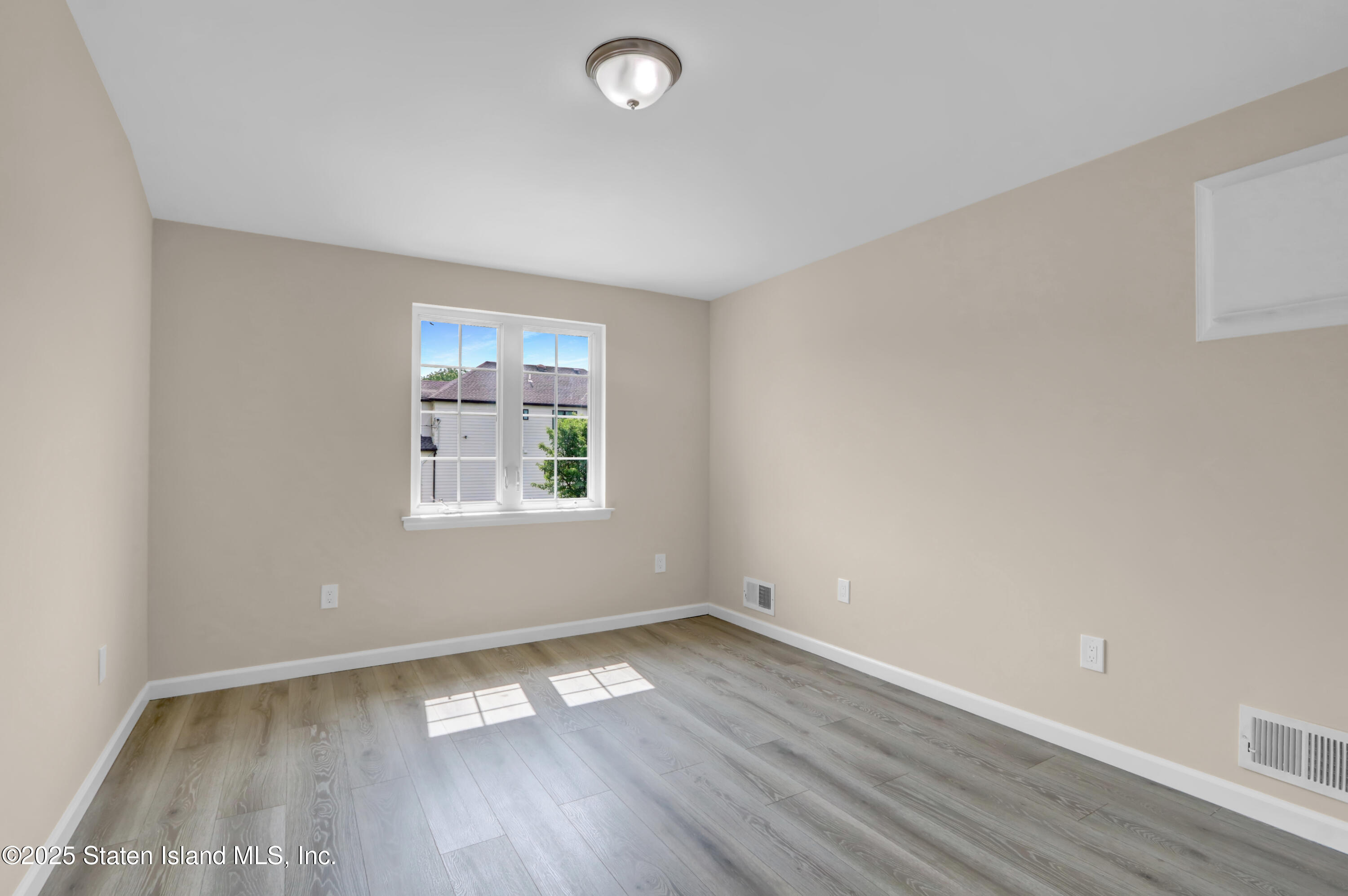 103 Savo Loop Staten Island, NY 10309 - Photo 39 of 46 an empty room with wooden floor and windows