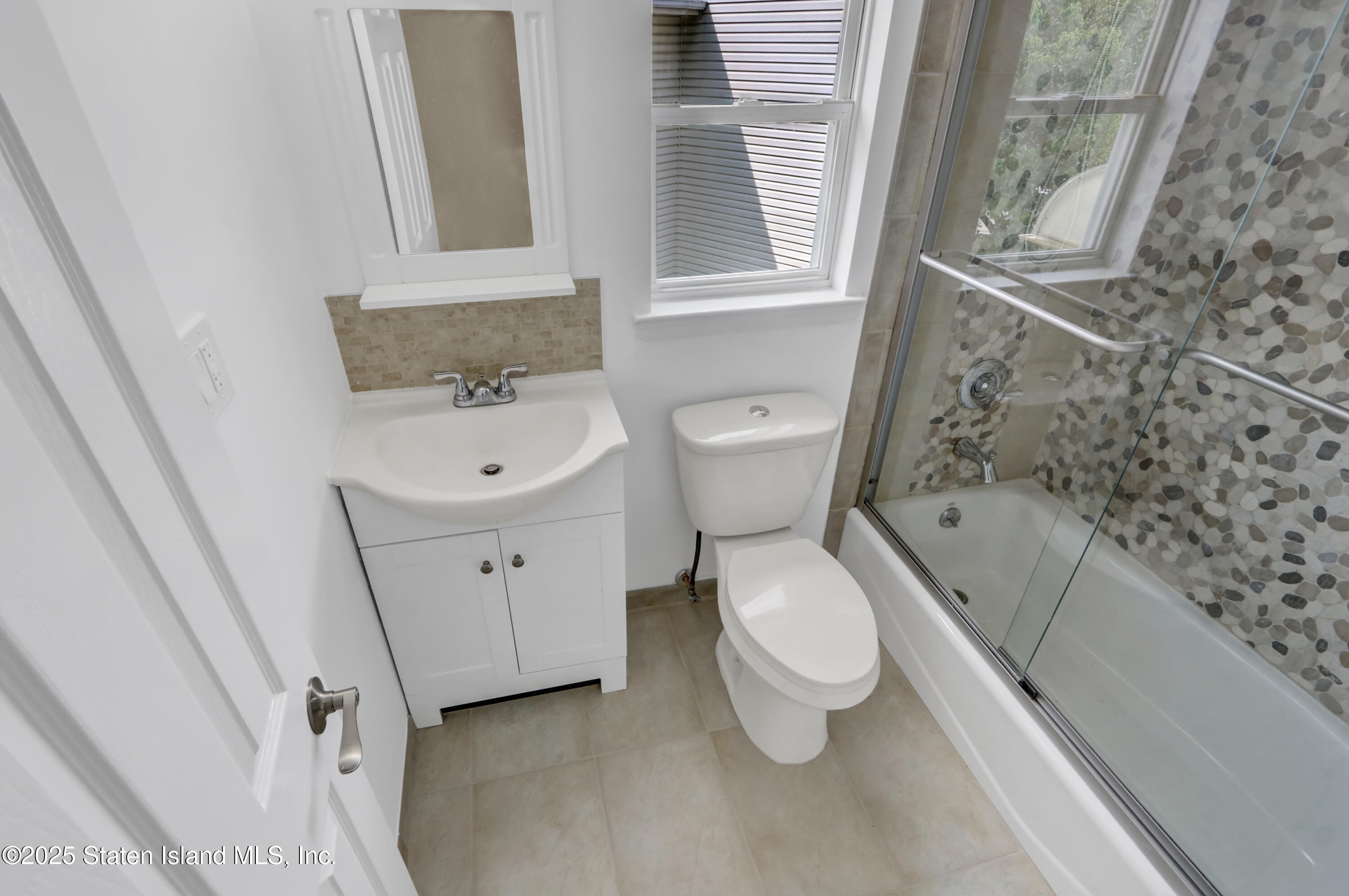 103 Savo Loop Staten Island, NY 10309 - Photo 45 of 46 a bathroom with a toilet sink and a mirror