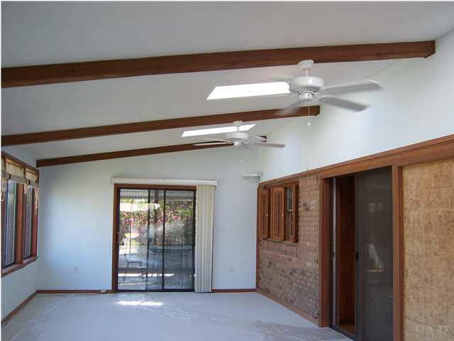 5610 Homewood Road Pensacola, FL 32504 - Photo 3 of 17 31x14 Sunroom off the kitchen views the back yard, has new carpet and there is a wood burning stove at one end, opens onto an enclosed patio