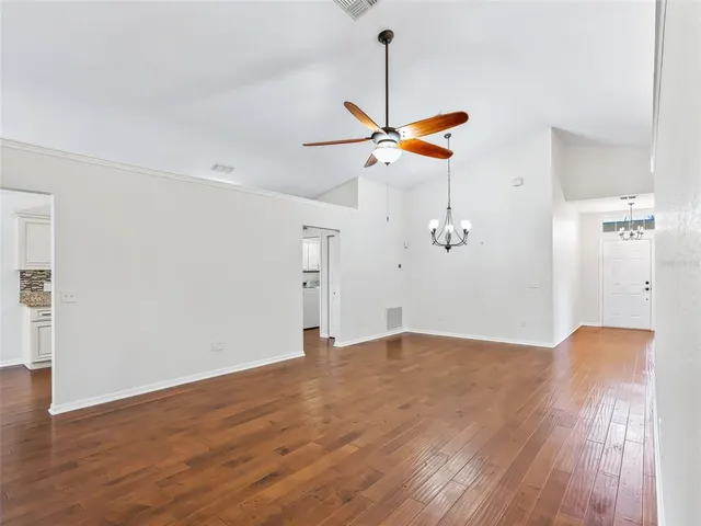 a view of a room with wooden floor and ceiling fan