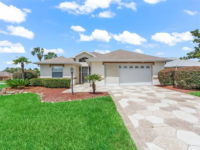 a front view of a house with a garden and yard