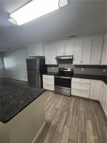 a kitchen with a refrigerator and a stove