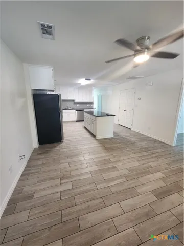 a view of a kitchen with refrigerator and cabinets