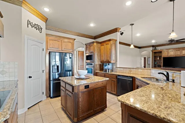 a kitchen with granite countertop a sink and wooden cabinets