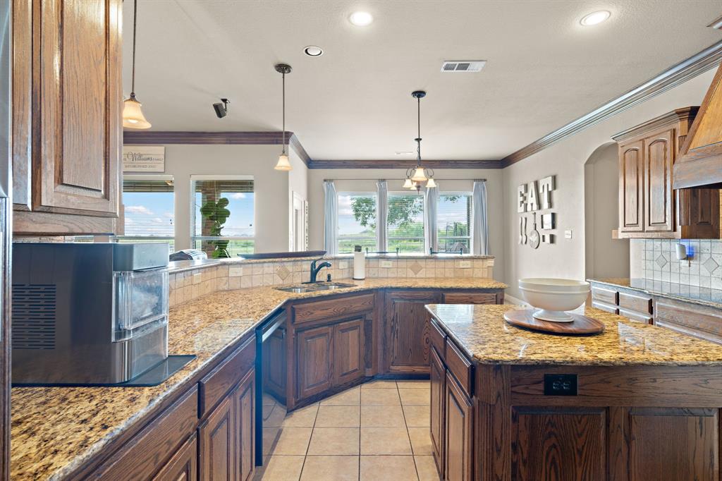 1341 Maxwell Road Haslet, TX 76052 - Photo 18 of 40 a kitchen with granite countertop a sink and wooden cabinets