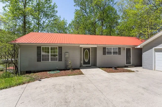 a front view of a house with yard and trees