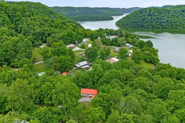 an aerial view of residential house with outdoor space and trees all around