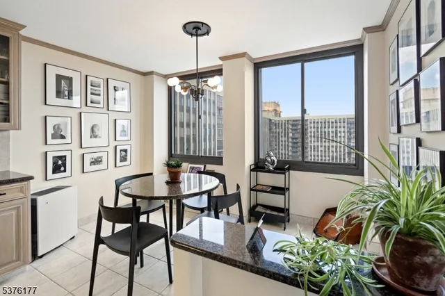 a dining room with furniture and large windows
