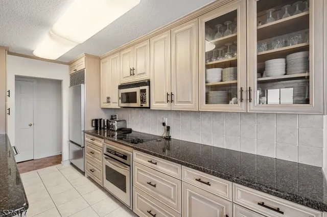 a kitchen with stainless steel appliances a sink dishwasher stove and cabinets