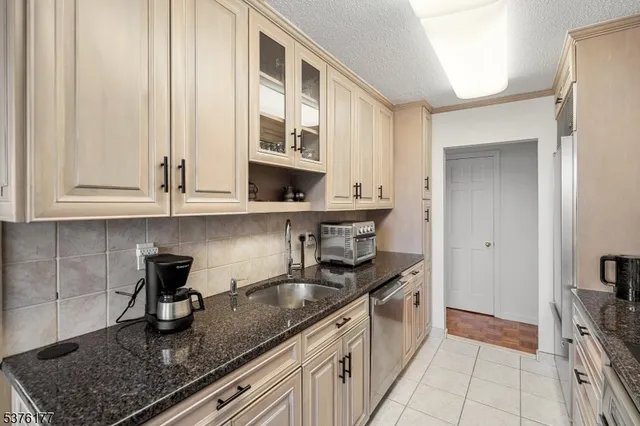 a kitchen with stainless steel appliances granite countertop a sink stove and cabinets