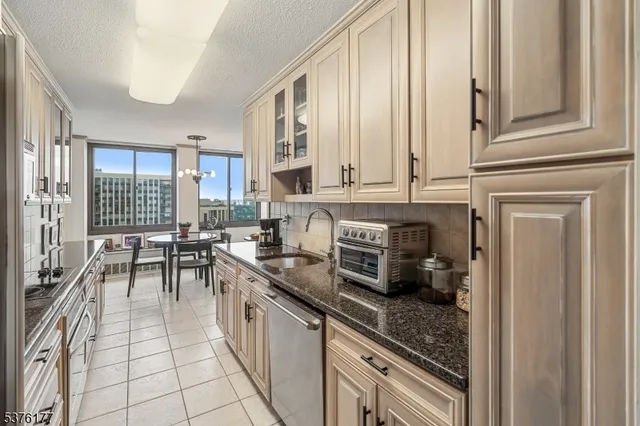 a kitchen with stainless steel appliances granite countertop a stove a sink and a refrigerator