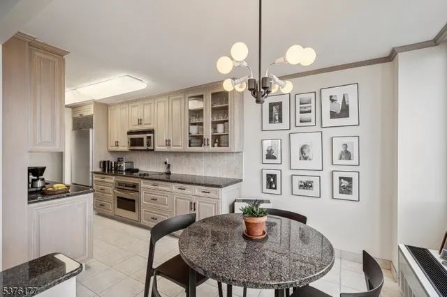 a kitchen with stainless steel appliances granite countertop a stove a sink a dining table and chairs