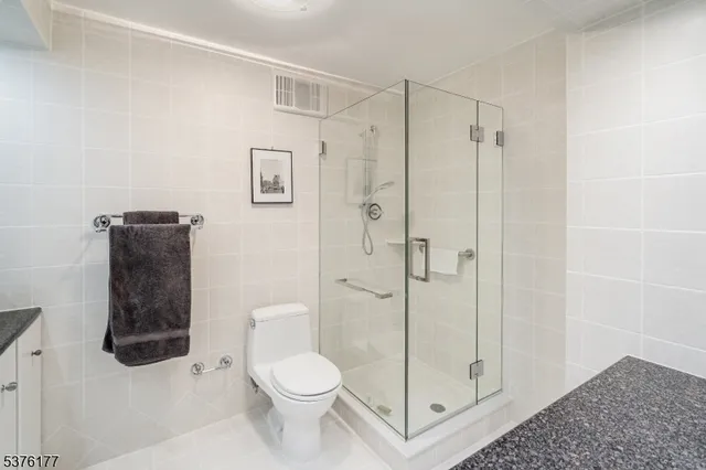 a bathroom with a granite countertop sink mirror and toilet