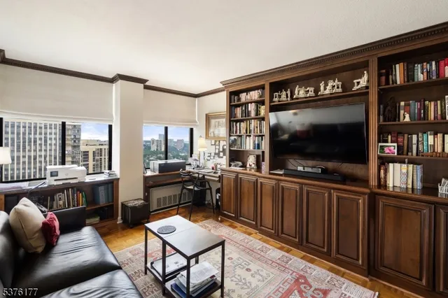 a living room with furniture a flat screen tv and a window