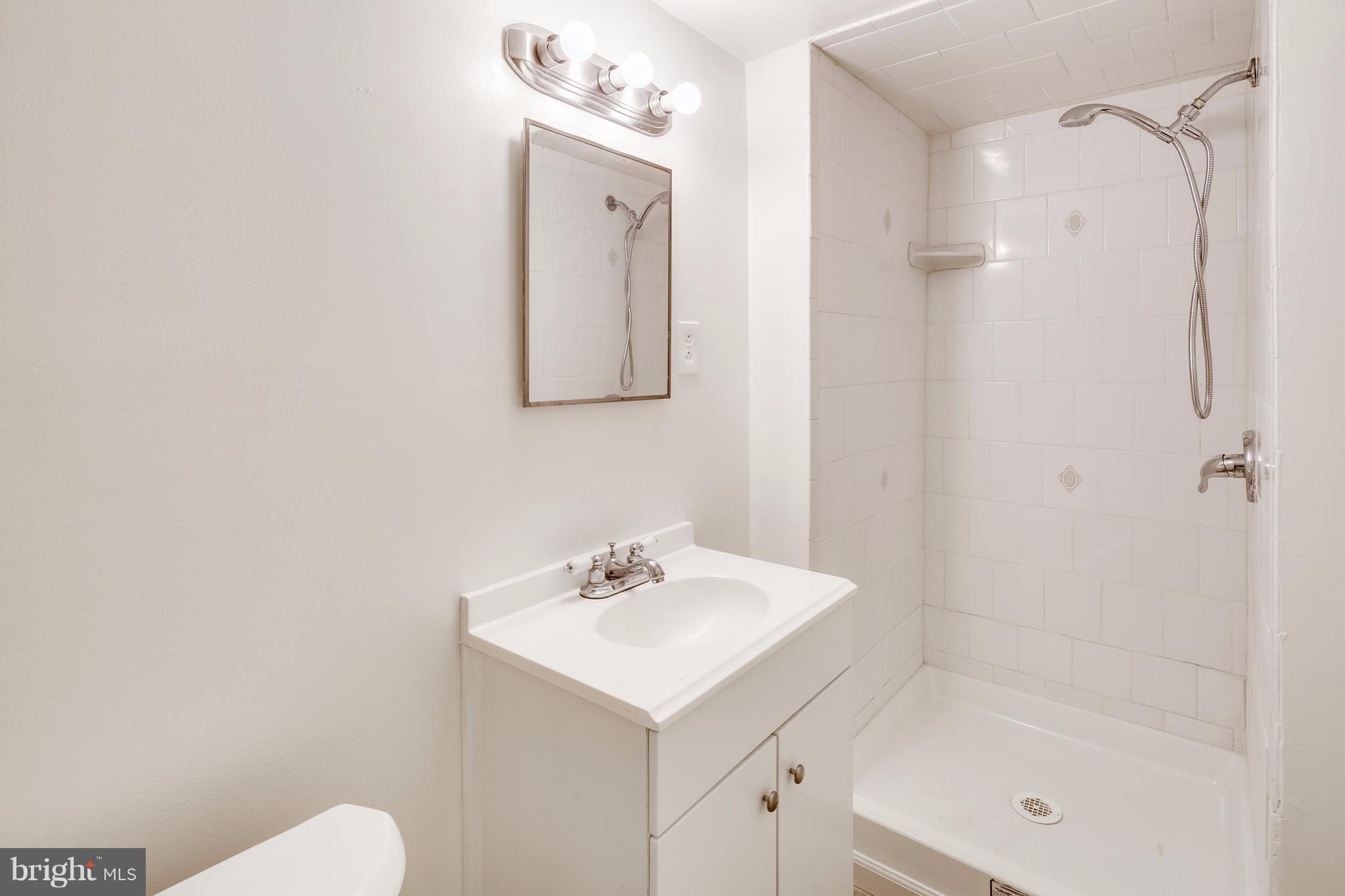 12025 Berry Street Silver Spring, MD 20902 - Photo 15 of 19 a bathroom with a sink mirror and shower