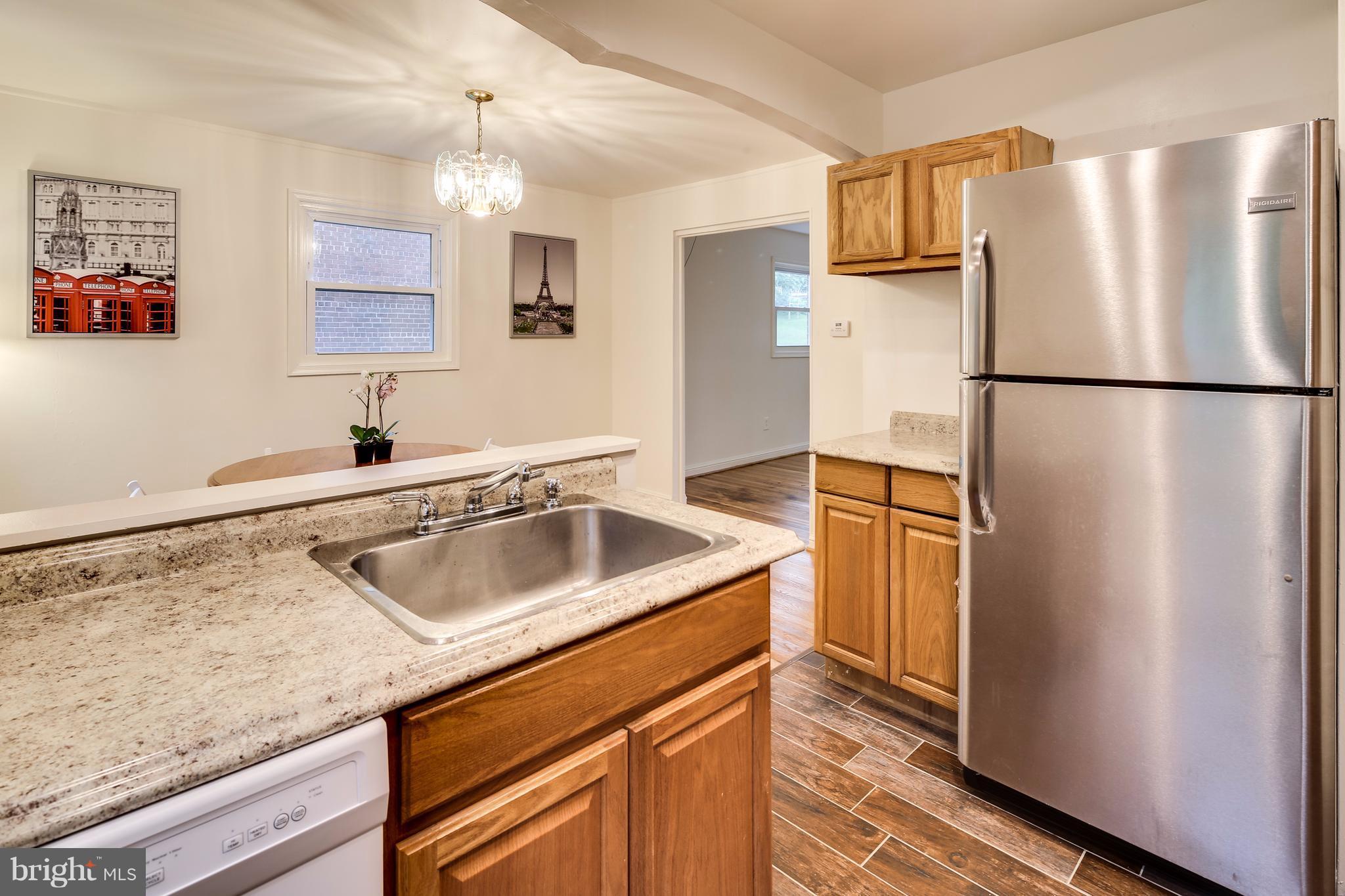 12025 Berry Street Silver Spring, MD 20902 - Photo 7 of 19 a kitchen with a refrigerator sink and cabinets