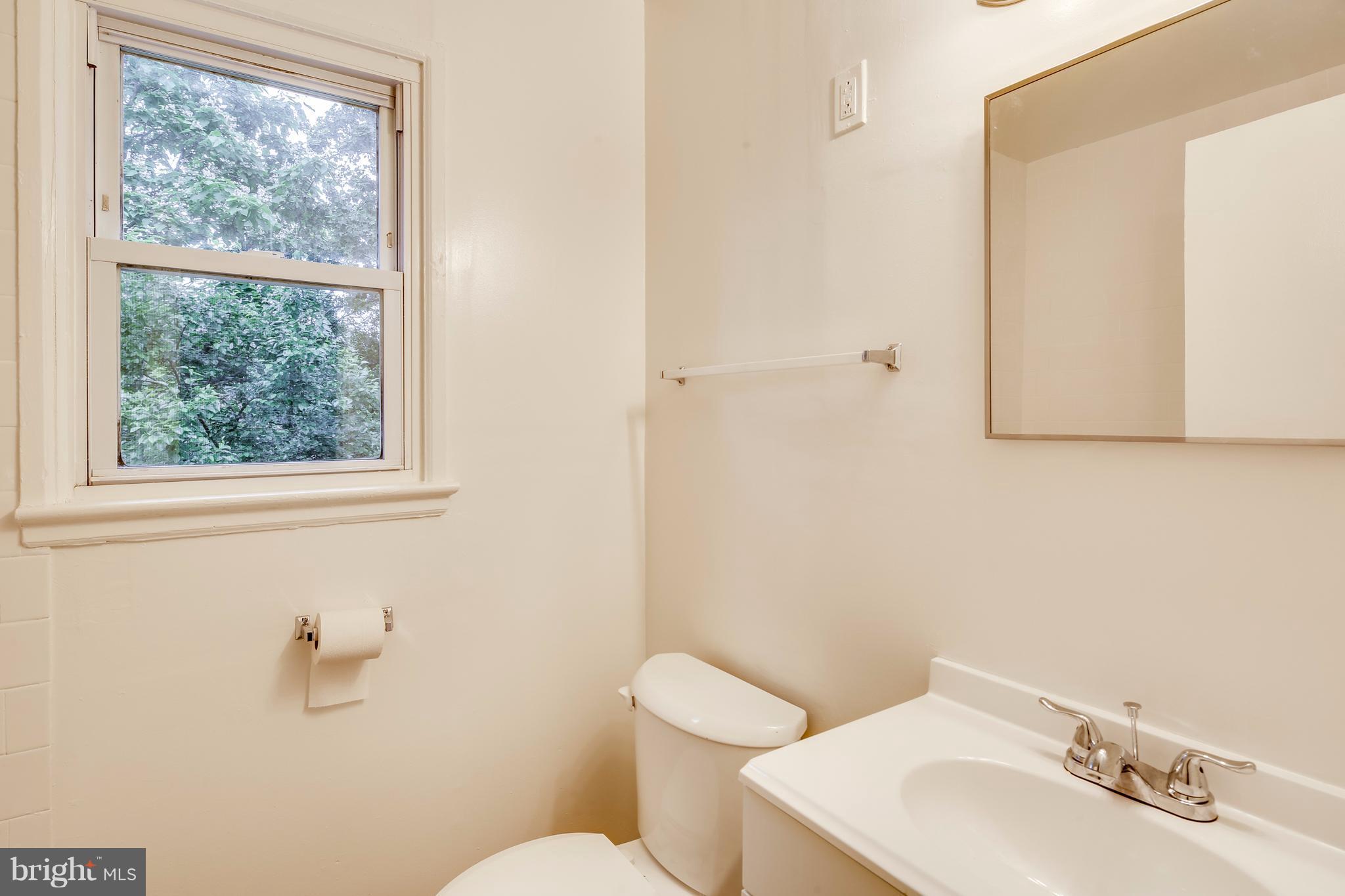 12025 Berry Street Silver Spring, MD 20902 - Photo 8 of 19 a bathroom with a sink mirror and toilet