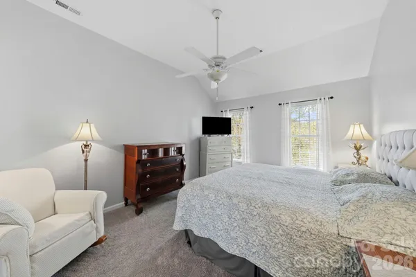 a bedroom with a bed wooden floor and ceiling fan