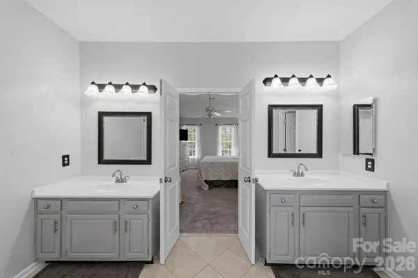a bathroom with a double vanity sink mirror and bathtub