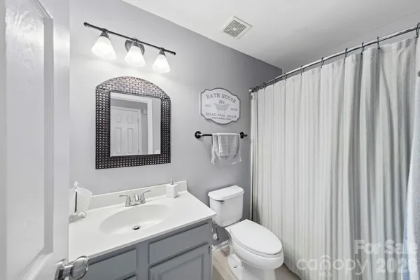a bathroom with a toilet a sink and a mirror