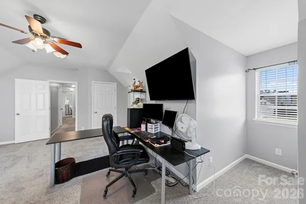 a view of a workspace with furniture and a window