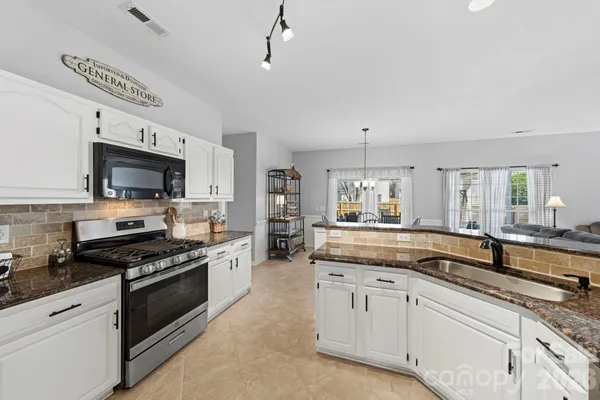 a large kitchen with cabinets a sink and a stove