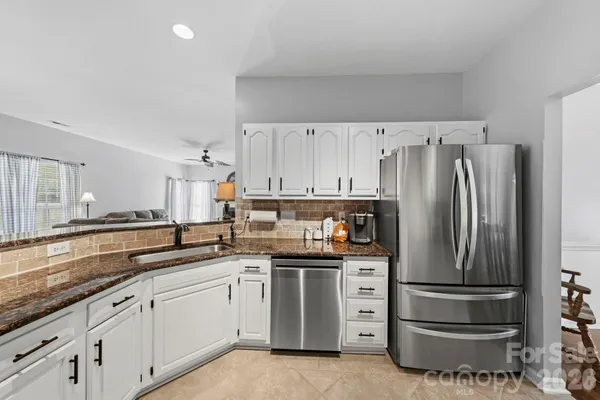 a kitchen with stainless steel appliances a refrigerator sink and cabinets
