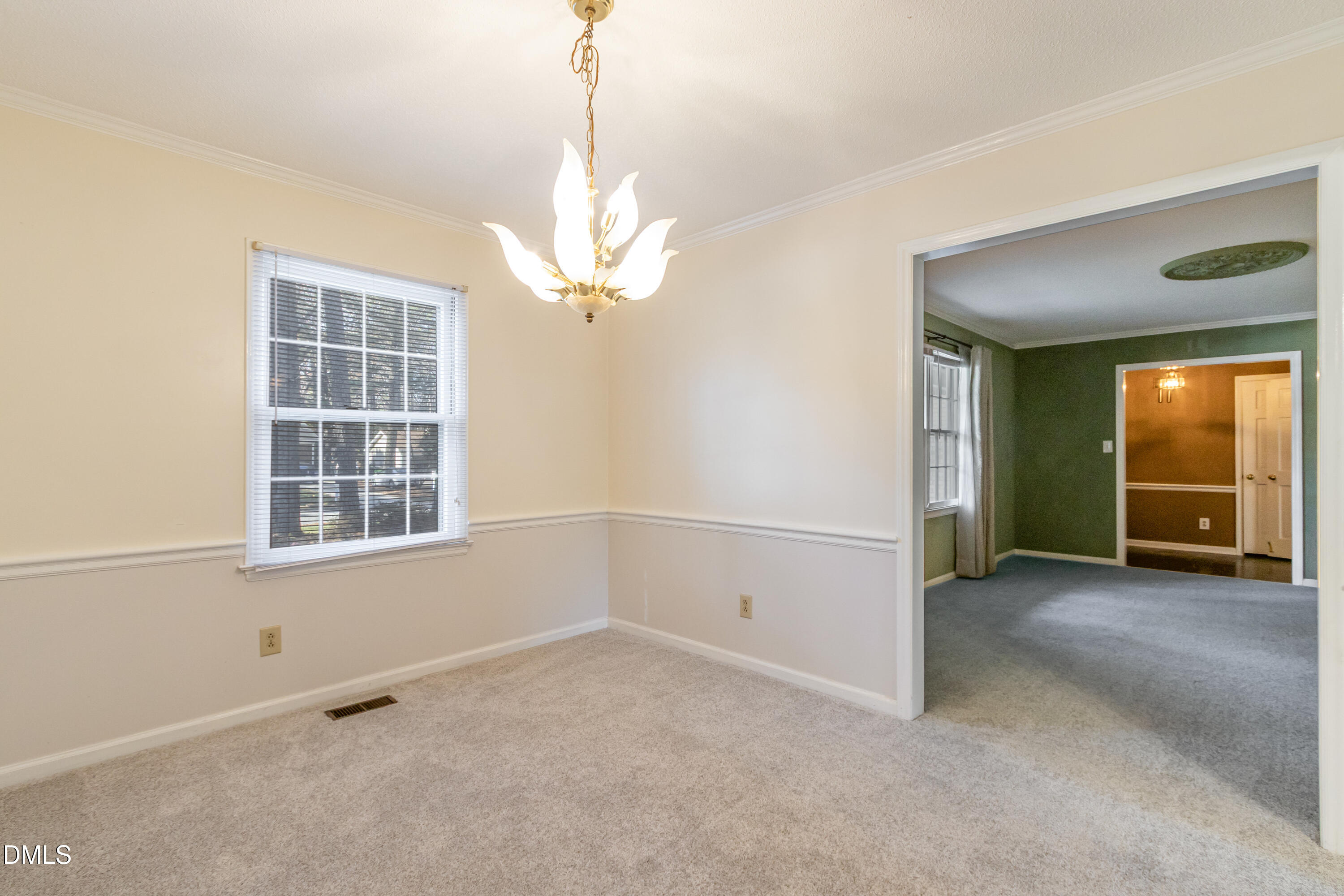 6800 Valley Drive Raleigh, NC 27612 - Photo 10 of 35 en empty room with windows and chandelier