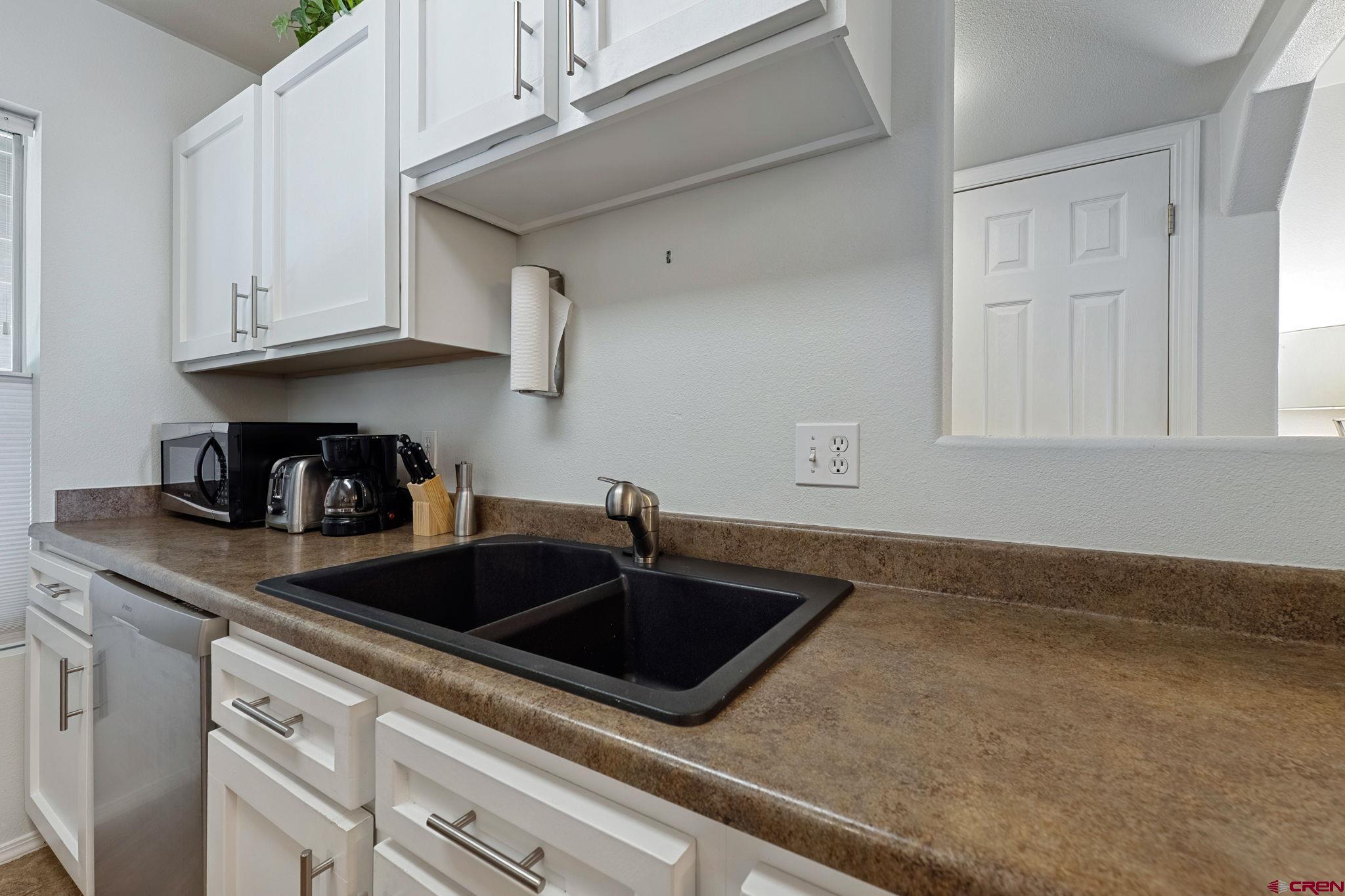 1100 Goeglein Gulch Road, Unit 225 Durango, CO 81301 - Photo 13 of 44 a kitchen with granite countertop white cabinets and sink