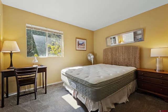 a bed room with a bed and a painting on the wall