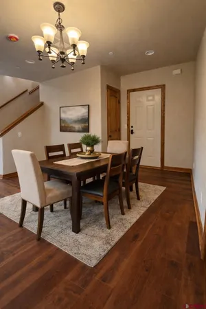 a view of a dining room with furniture a chandelier and wooden floor