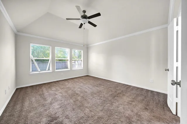 an empty room with a window and a fan