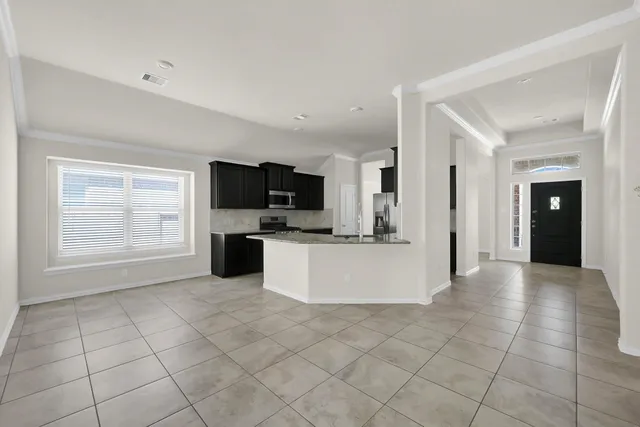 a view of a kitchen with an empty space and a window