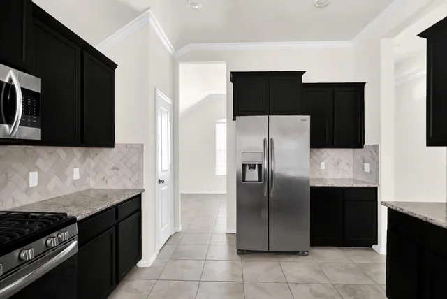 a kitchen with a refrigerator and a stove
