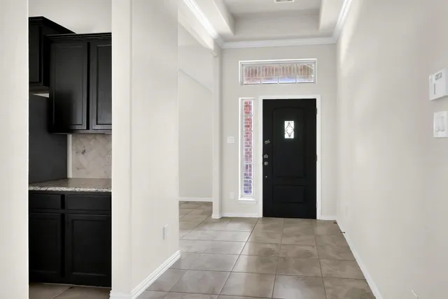 a kitchen with granite countertop a stove a microwave and a refrigerator