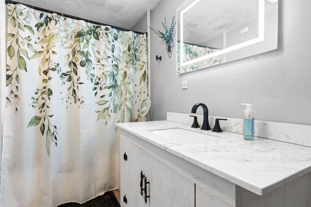 74 Princeton Street Gardner, MA 01440 - Photo 12 of 26 a bathroom with a granite countertop sink and a mirror