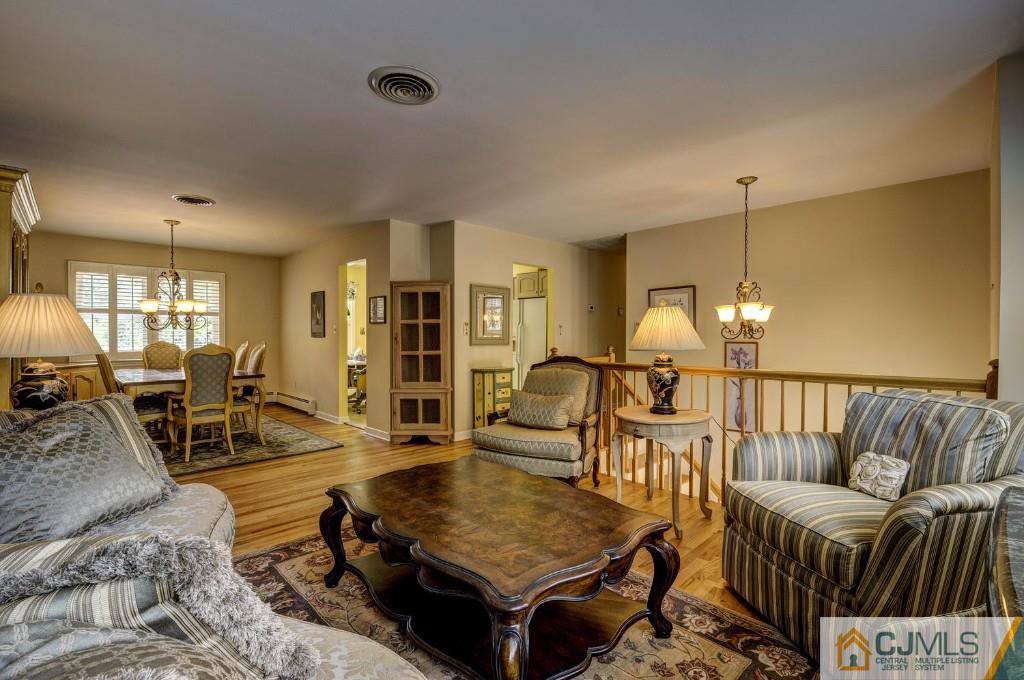 830 Inman Avenue Edison, NJ 08820 - Photo 20 of 21 a living room with furniture a dining table and chairs with wooden floor