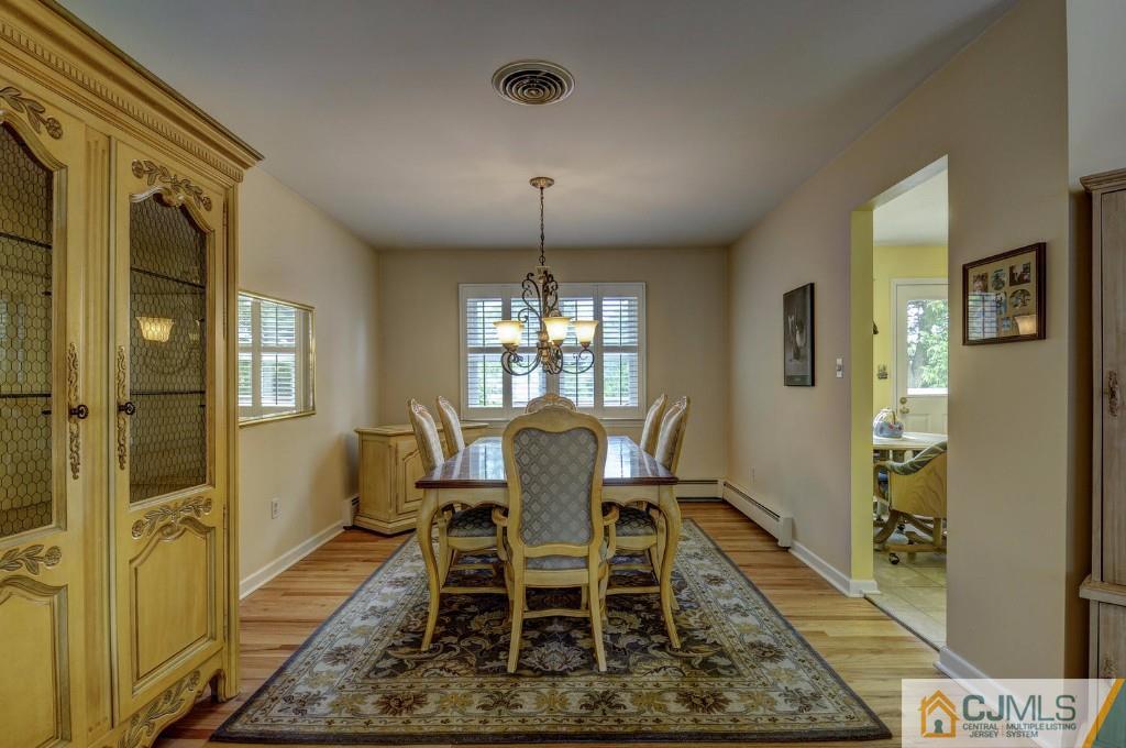830 Inman Avenue Edison, NJ 08820 - Photo 6 of 21 a dining room with wooden floor and a chandelier