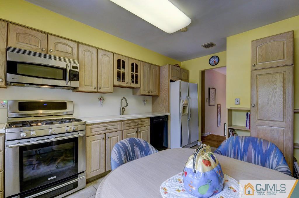 830 Inman Avenue Edison, NJ 08820 - Photo 7 of 21 a kitchen with stainless steel appliances a stove a microwave a sink a refrigerator and cabinets