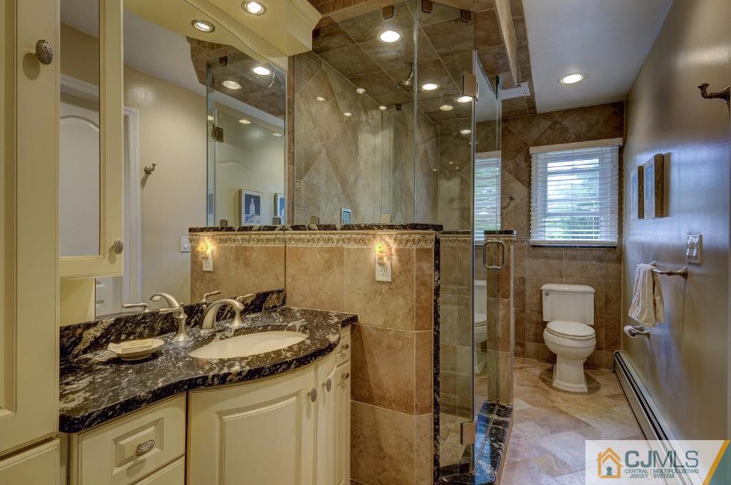 830 Inman Avenue Edison, NJ 08820 - Photo 10 of 21 a bathroom with a granite countertop sink a toilet a mirror and shower