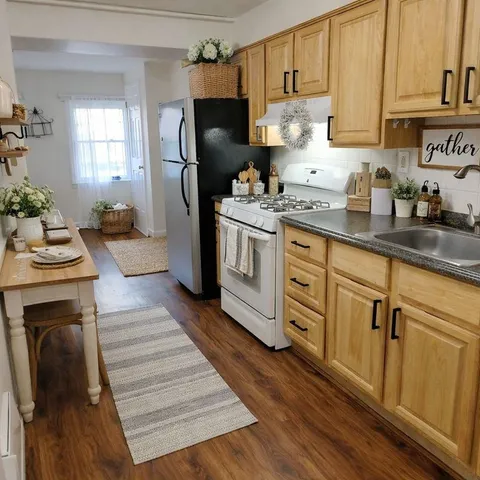 a kitchen with granite countertop a refrigerator stove and sink