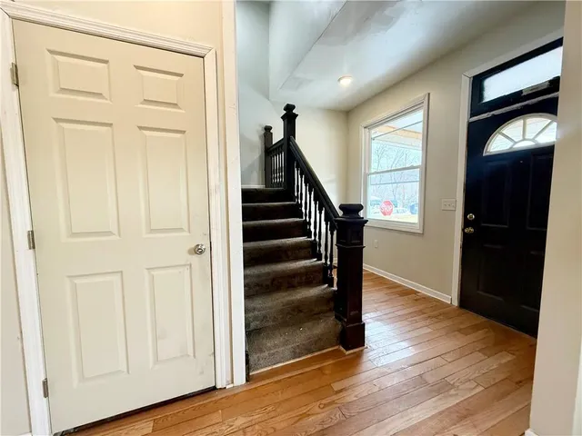 a view of a hallway with wooden floor and staircase