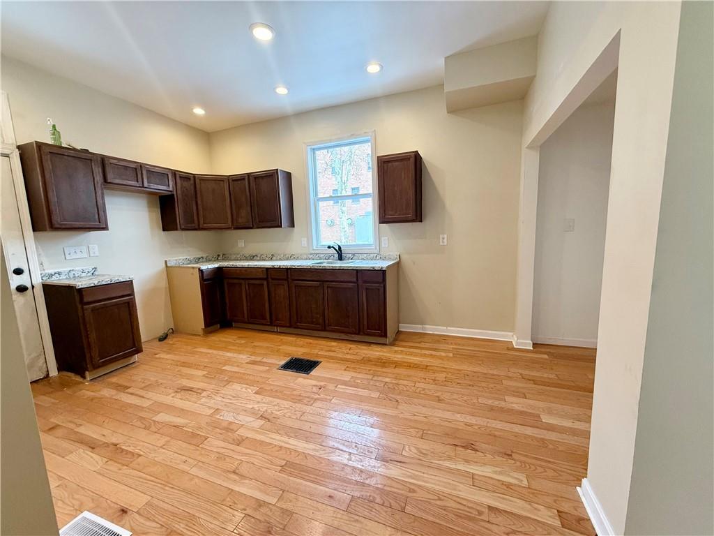 841 2nd Avenue Beaver Falls, PA 15010 - Photo 7 of 23 a kitchen with stainless steel appliances granite countertop a sink and a stove top oven with wooden floor
