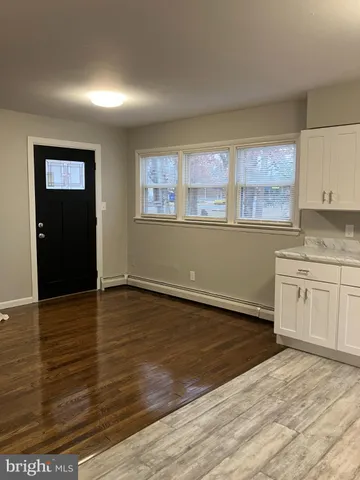 a view of a kitchen with wooden floor and electronic appliances