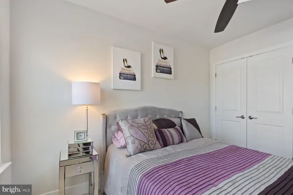 a bedroom with a bed and a lamp on the dresser