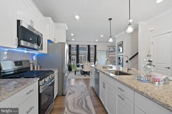 a kitchen with stainless steel appliances granite countertop a sink a stove top oven a counter space and cabinets