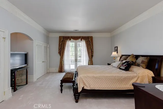a bedroom with a bed a fireplace and a large window