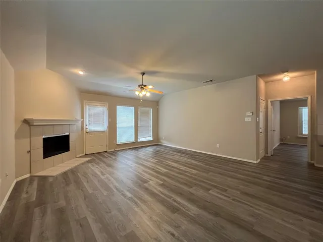 a view of empty room with wooden floor and fireplace